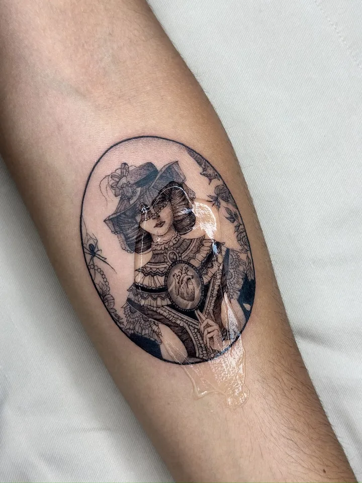 Fine-line tattoo by nurse.tattoo: an oval cameo with an anatomical heart, on a forearm