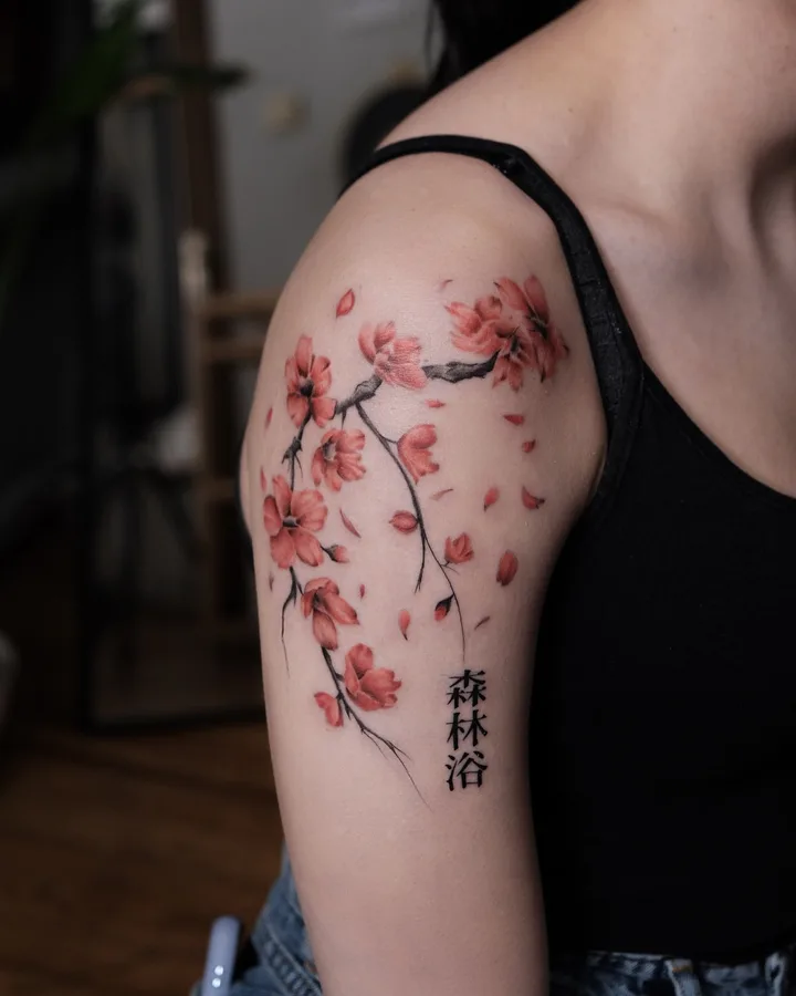 A sakura branch with falling petals and the characters 森林浴, red and black on the upper arm, finished